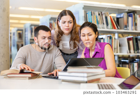 Female and male colleagues working together in public library Female and male colleagues working together in public library 103463291