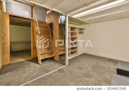 the inside of an unfinished room with stairs leading up to the second floor and storage space on the right side 103463348