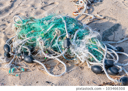 Remnants of fishing nets washed up on the beach (image of marine pollution) Remnants of fishing nets washed up on the beach (image of marine pollution) 103466308