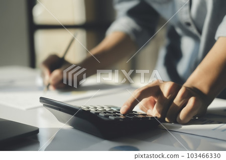 Accountant using calculator for calculate finance report in office. Accountant using calculator for calculate finance report in office. 103466330