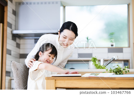 mother teaching her daughter to study at home 103467766