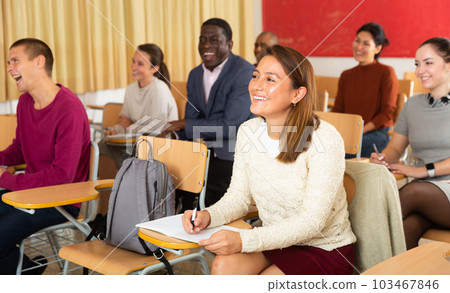 Multiethnic group of adult people studying together at tables in classroom Multiethnic group of adult people studying together at tables in classroom 103467846