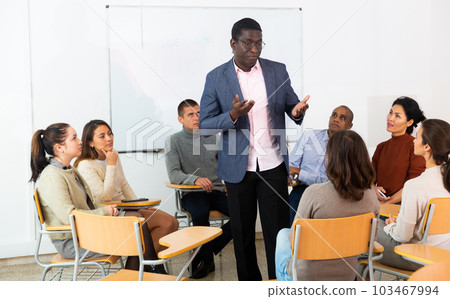 Portrait of man giving speech during therapy session in support group Portrait of man giving speech during therapy session in support group 103467994