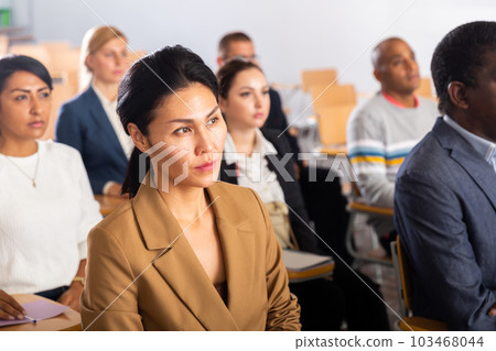 Asian businesswoman sitting at corporate seminar in conference room Asian businesswoman sitting at corporate seminar in conference room 103468044