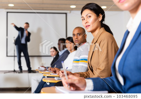 Asian businesswoman sitting at corporate seminar in conference room Asian businesswoman sitting at corporate seminar in conference room 103468095