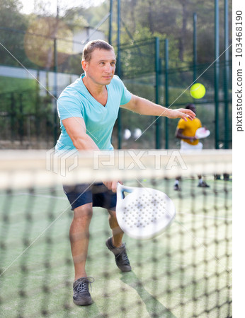 European man padel tennis player trains on the court 103468190