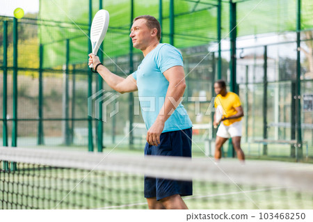 Male padel tennis player training on court Male padel tennis player training on court 103468250