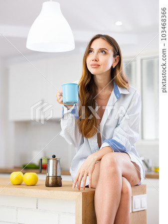 Smiling woman drinking coffee at home Smiling woman drinking coffee at home 103468366