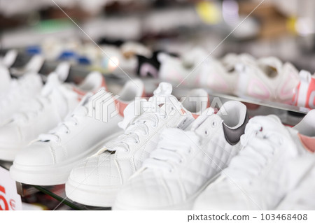 Shelves with different sport shoes in shoes shop 103468408