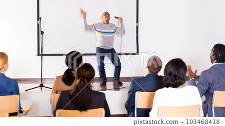 Male coach giving speech at conference hall 103468418