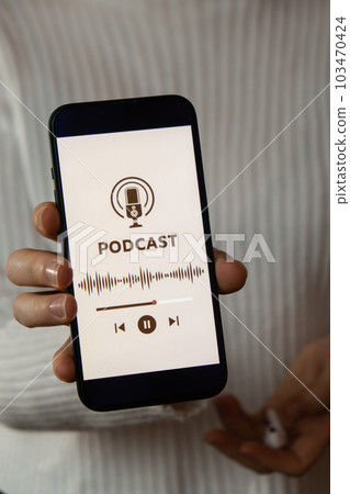 Unrecognizable woman holding mobile phone Podcast listening website page app application with wireless headphones. Audio healing, sound therapy wellness rituals, positive mental health habits Unrecognizable woman holding mobile phone Podcast listening website page app application with wireless headphones. Audio healing, sound therapy wellness rituals, positive mental health habits 103470424