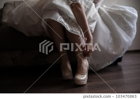 bride fastening shoes 103470863