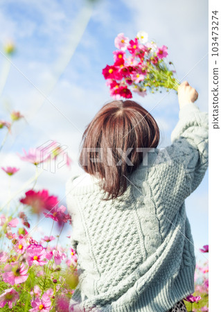 一個拿著花束站在宇宙田裡的女人 103473274