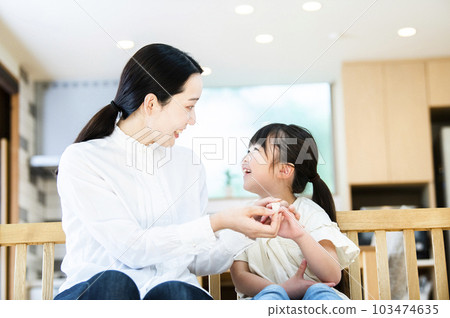 Mother putting a band-aid on her daughter 103474635