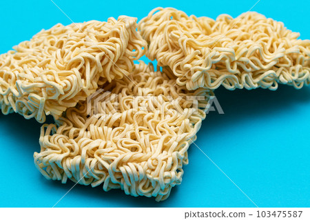 Uncooked Instant Noodles on Blue Background Uncooked Instant Noodles on Blue Background 103475587