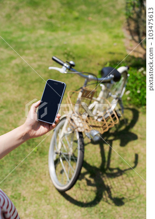 操作自行車和智能手機的女性手部照片 103475613