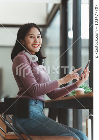 Online store icon, shopping on internet, Asian woman using on virtual screen with hands choosing on smartphone application 103477707