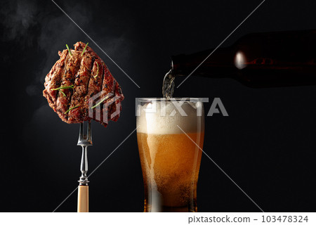Grilled ribeye beef steak with rosemary and glass of beer. 103478324