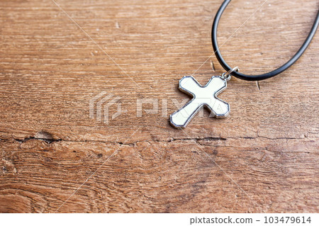 Christian cross on wooden table with window light 103479614