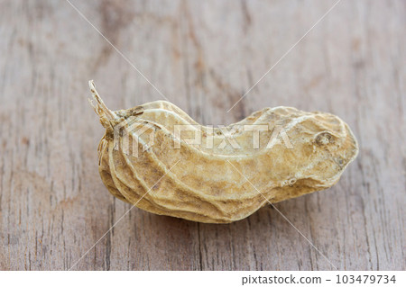 Roasted or row peanuts scattered on rustic, dark wood table background. 103479734