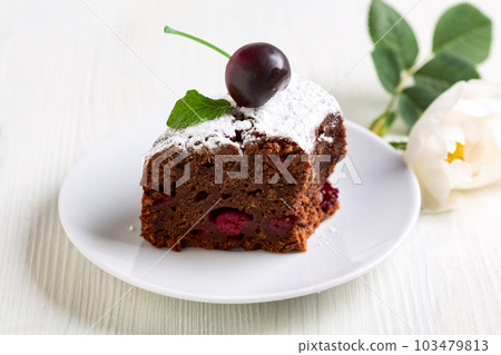 Piece of chocolate cake with cherries in close-up. 103479813