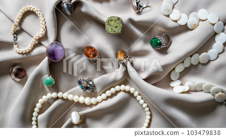 Many different silver rings and necklace with various natural gemstones over background. Many different silver rings and necklace with various natural gemstones over background. 103479838