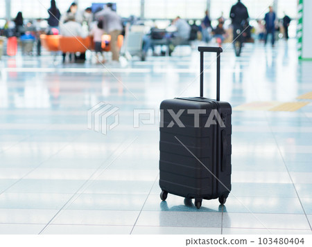 機場出發大廳的黑色手提箱 103480404