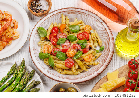 Italian pasta adorned with fresh tomatoes and aromatic basil 103481252