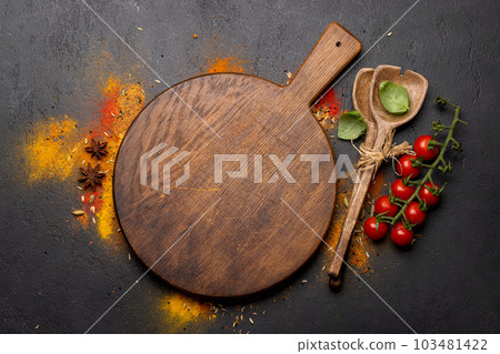 Empty cutting board over various spices 103481422