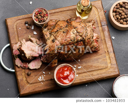 Baked pork collar with spices on a wooden board, delicious and juicy meat Baked pork collar with spices on a wooden board, delicious and juicy meat 103481933