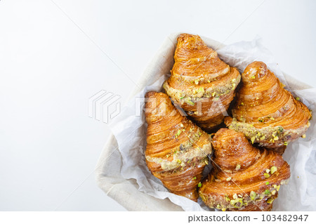 Fresh croissants on white table in basket 103482947
