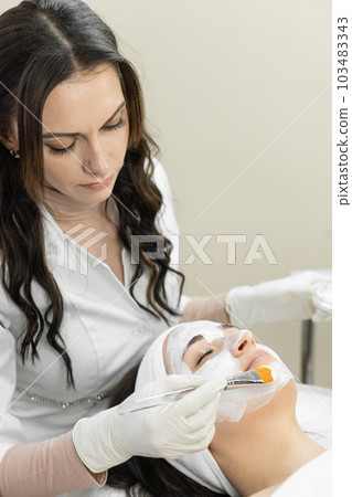 Luxury care in a beauty clinic: this photo shows how a cosmetology mask creates luxurious skin care in a beauty clinic, providing a sense of comfort and pleasure for a young woman Luxury care in a beauty clinic: this photo shows how a cosmetology mask creates luxurious skin care in a beauty clinic, providing a sense of comfort and pleasure for a young woman 103483343