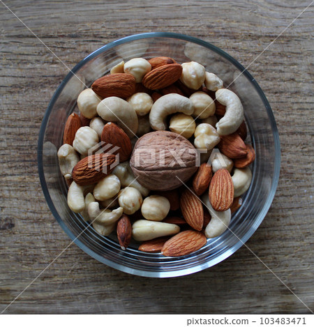 Whole Walnut In A Center Of Glass Bowl With Mix Of Different Shelled Nuts On Wooden Surface Square Stock Photo Whole Walnut In A Center Of Glass Bowl With Mix Of Different Shelled Nuts On Wooden Surface Square Stock Photo 103483471