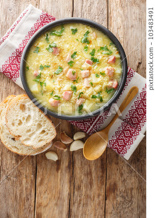 Traditional Ukrainian rich soup kulish from millet with cracklings close-up in a plate. vertical top view 103483491
