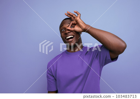 young positive friendly african guy with a short haircut dressed in a basic t-shirt against the 103483713