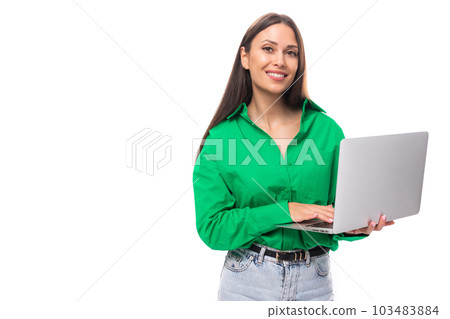 well-groomed brunette long-haired young business woman in a green shirt works in the IT sphere on a 103483884