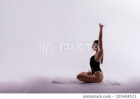 Image of young plump female doing acrobatic stunt, studio shot 103484521