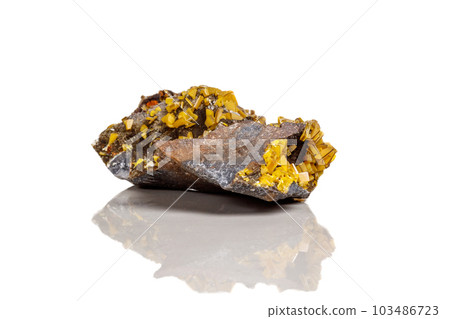 Macro mineral stone yellow Wulfenite on a white background 103486723