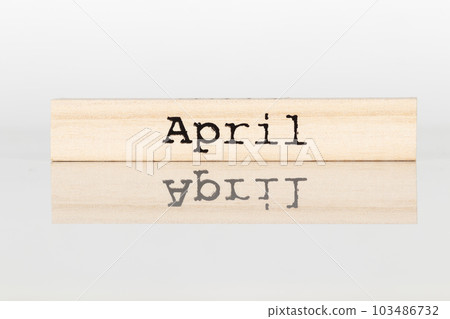 wooden cube with an inscription April on a white background 103486732
