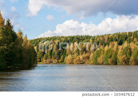 Water landscape. A river bend and an autumn forest in September. Bright colours of autumn Water landscape. A river bend and an autumn forest in September. Bright colours of autumn 103487612