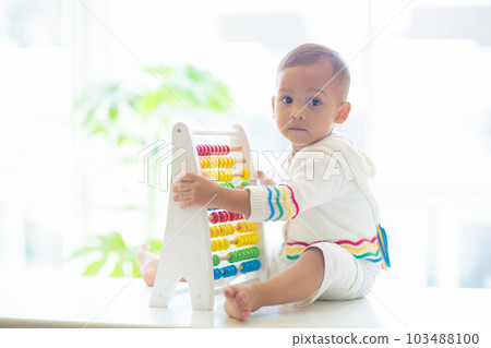 Baby boy playing with wooden abacus. Baby boy playing with wooden abacus. 103488100
