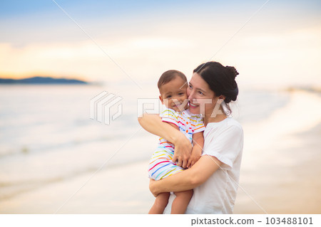 Mother and baby on tropical beach at sunset. 103488101