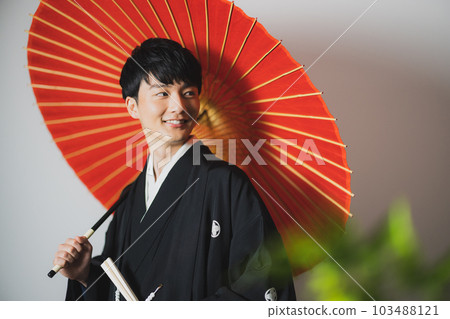 一個穿著帶徽章的袴的男人，一把日本傘 103488121