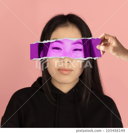 Attentive concentrated look. Asian beautiful young woman and human hand covering eyes with photo face part. Conceptual art collage. 103488149