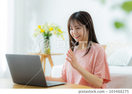 一個女人在客廳裡看電腦 103488275