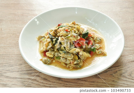 spicy stir fried clams with slice chili and basil leaf on plate  103490733