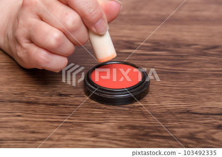 [Woman putting ink on seal] 103492335