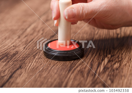 [Woman putting ink on seal] 103492338