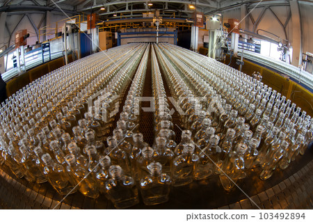 Glassworks. Glass industry. Many glass bottles on a factory conveyor. Glassworks. Glass industry. Many glass bottles on a factory conveyor. 103492894