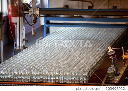 Glassworks. Glass industry. Many glass bottles on a factory conveyor. Glassworks. Glass industry. Many glass bottles on a factory conveyor. 103492912